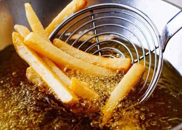 Golden French fries frying in hot oil at Chefstemp.
