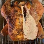 Whole roasted turkey with crispy skin and juicy meat, perfect for holiday celebrations.