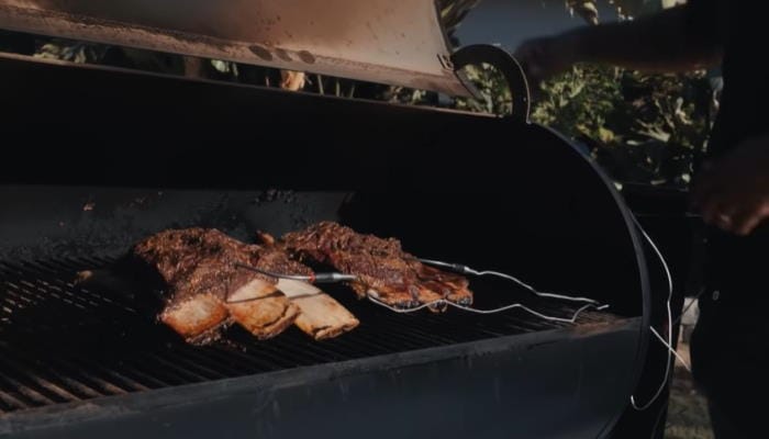 Juicy ribs and brisket smoking on a grill for perfect barbecue results.