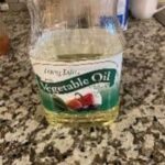 Vegetable oil in a glass jar on a kitchen countertop.